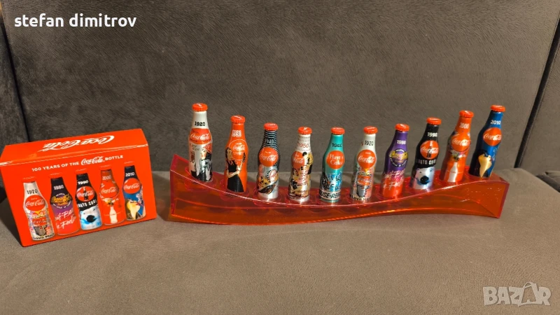 Coca Cola 100 години комплект бутилки, 10 мини алуминиеви бутилки с поставка, снимка 1