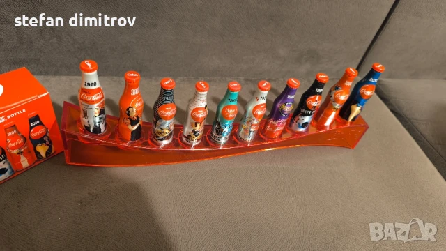 Coca Cola 100 години комплект бутилки, 10 мини алуминиеви бутилки с поставка, снимка 11 - Колекции - 51381112