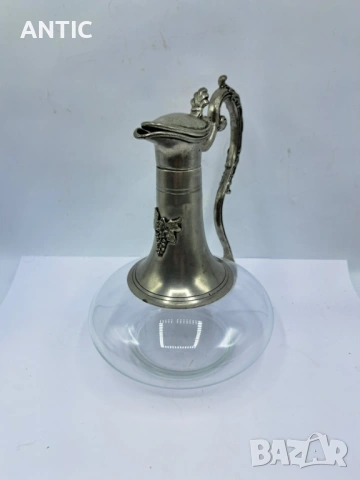 Красив декантер със заоблено тяло и капак на панти. 