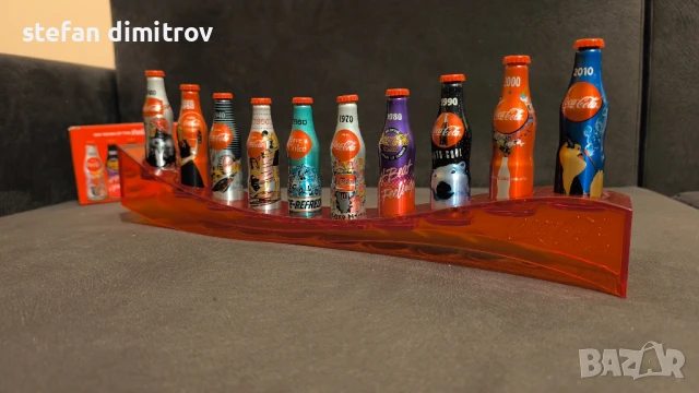 Coca Cola 100 години комплект бутилки, 10 мини алуминиеви бутилки с поставка, снимка 8 - Колекции - 51381112