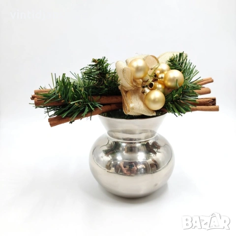 Декорация, включваща елхови клонки, канелени пръчки и златни топки във ваза