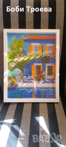 Живописна синьо-жълта картина на морска къща с балкон с цветя