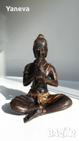 Бронзова статуетка на музикант в медитация , излъчващ спокойствие и духовна хармония. 